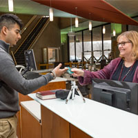 photo of a student and staff member in the library