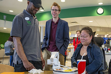 photo of a student with a staff member and obi
