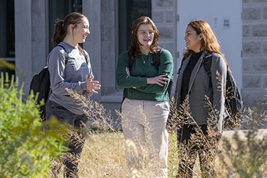 photo of students standing and talking outside on campus