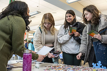 photo of a staff member and students at a study abroad fair