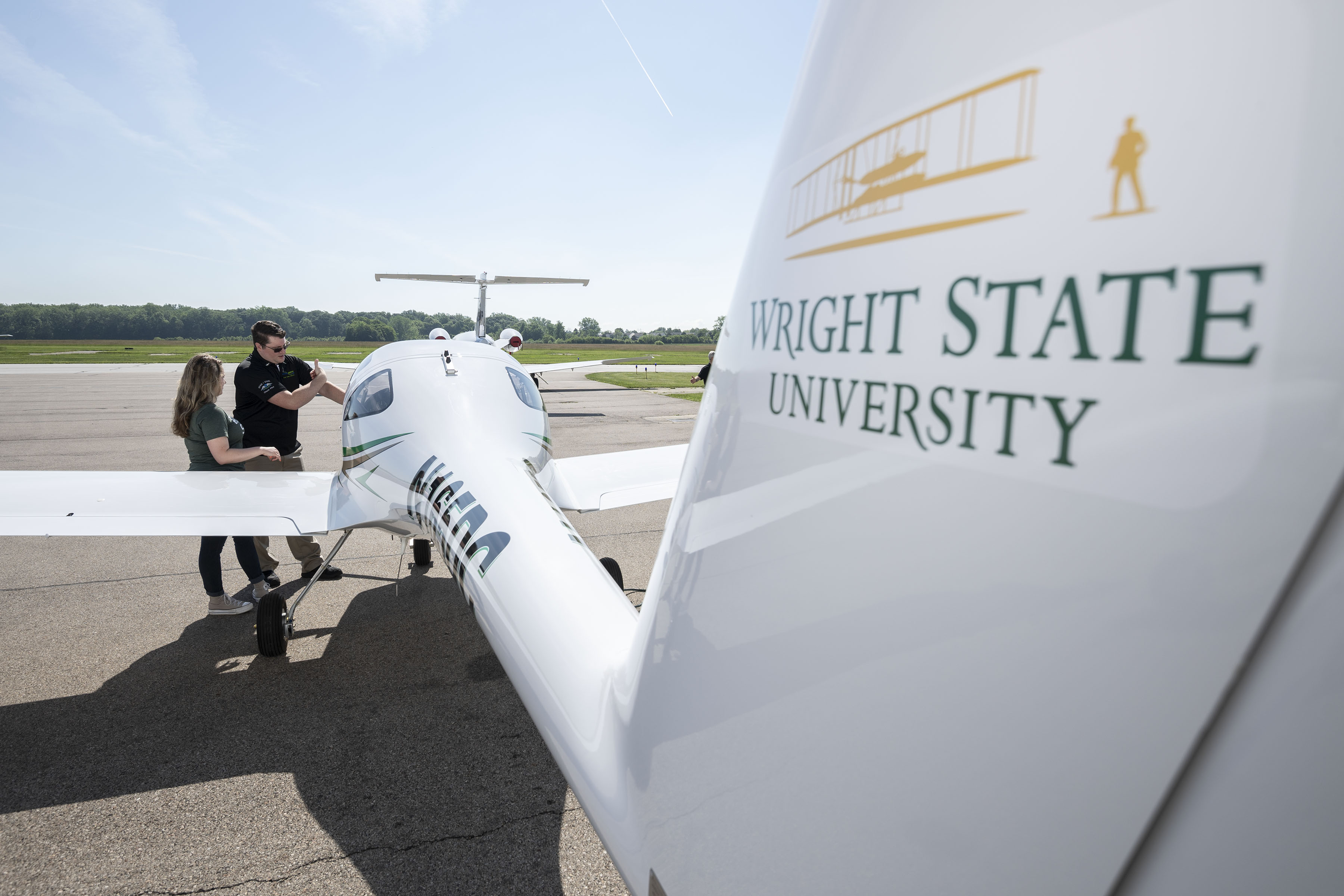 photo of a student and instructor standing by an airplane