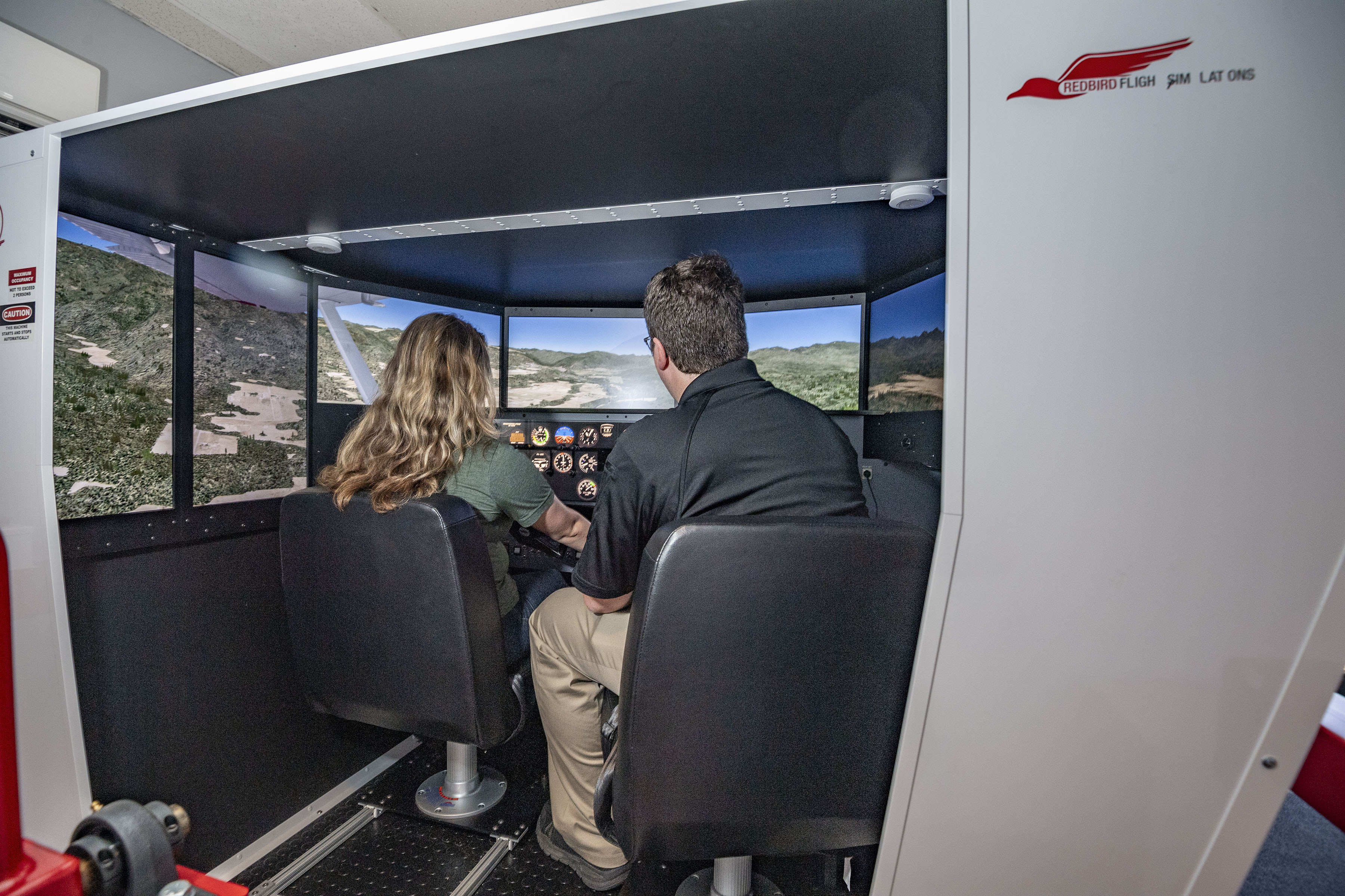 photo of a student and instructor in a flight simulator
