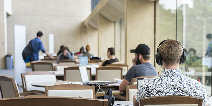photo of students sitting at tables studying in the library
