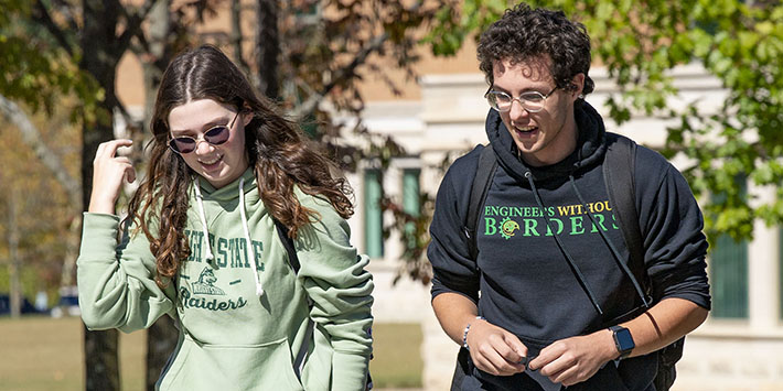 photo of two students walking outside on campus