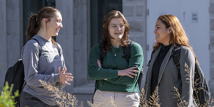 photo of students standing and talking outside on campus