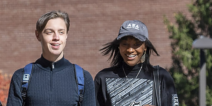 photo of two students walking outside on campus