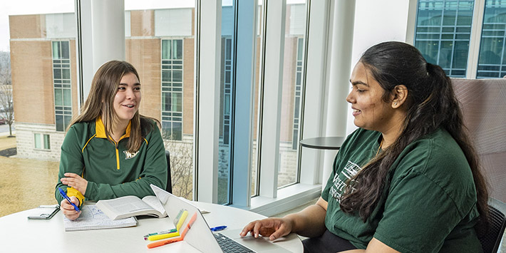 photo of two students sitting at a table in the student success center