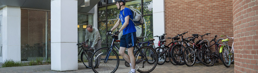photo of an employee and bicycle on campus