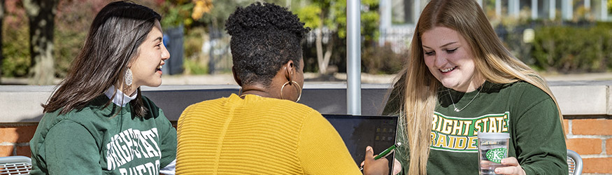 photo of students studying at a table outside on campus