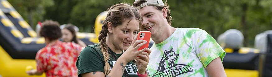 photo of students on campus looking at an iphone