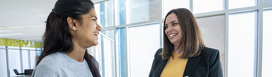 photo of a student and staff member standing and talking