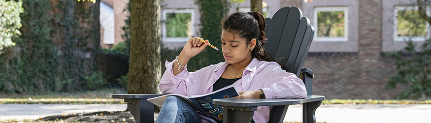 photo of a student sitting outside on campus