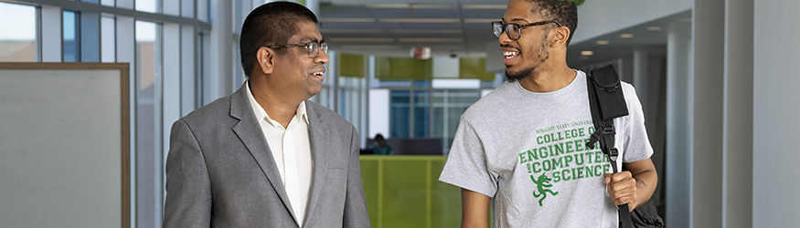 photo of a student and professor walking and talking