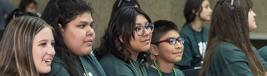 photo of students sitting and listening to a speaker