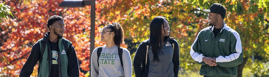 photo of students walking and talking outside on campus