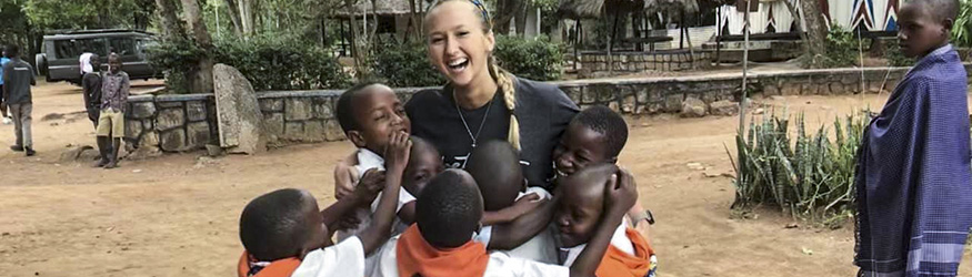 photo of a student hugging children on a study abroad experience