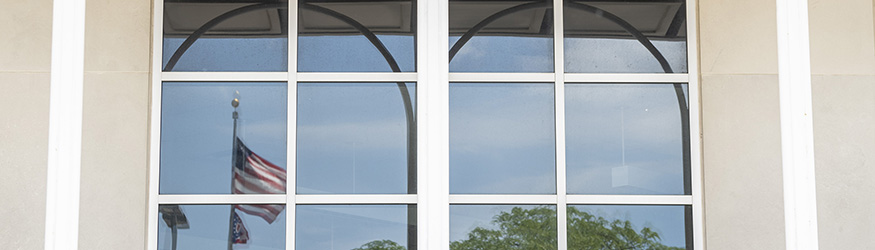 photo of flags reflected in the windows of allyn hall