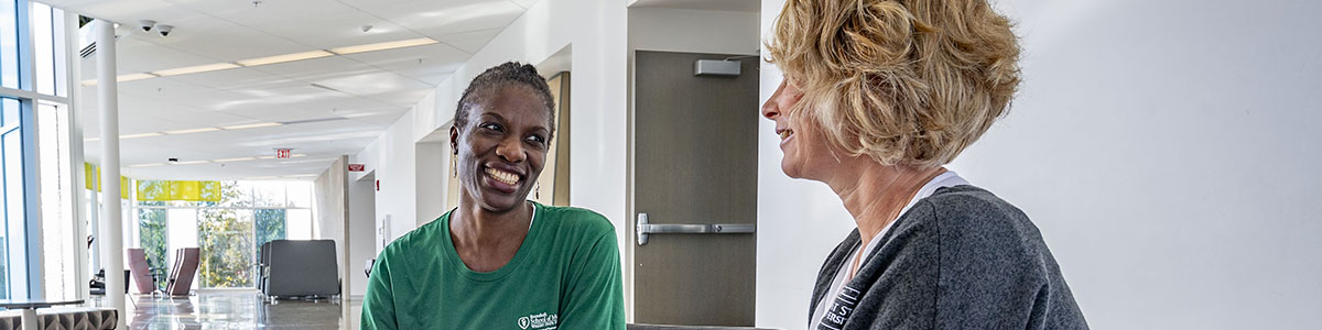 photo of a student and staff member sitting and talking