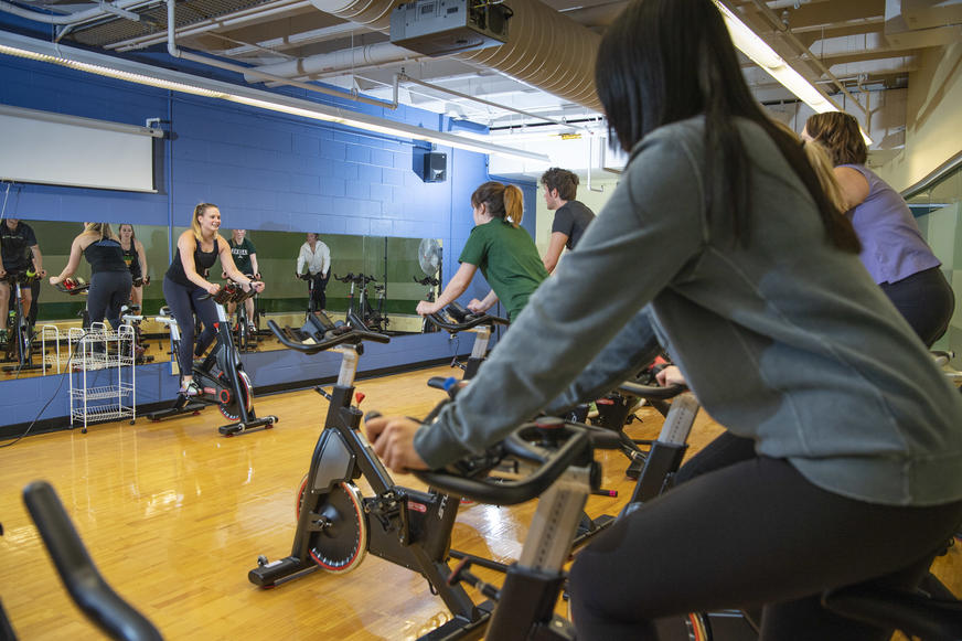 photo of an instructor and students in a cycling class