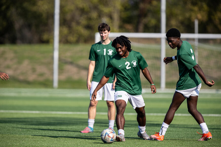 Three Men's Club Soccer players warming up pregame. 