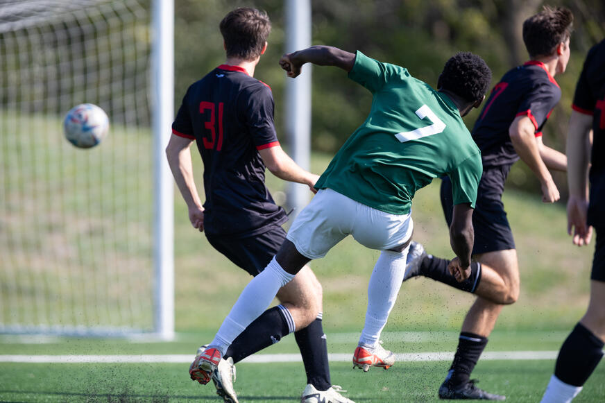 Soccer player shooting ball at goal